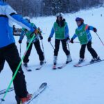 Bambini con sci e caschi colorati durante una lezione sulla neve con la Scuola di Sci Val di Luce – Abetone