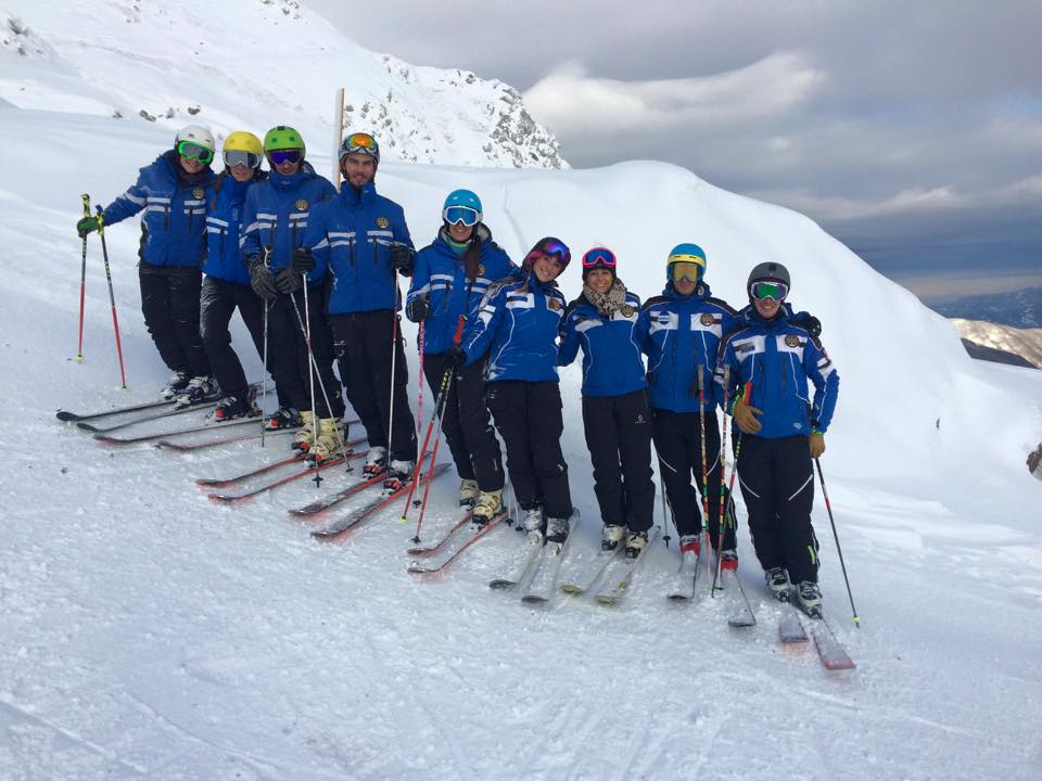 I maestri della Scuola di Sci Val di Luce – Abetone in posa sulla neve, con abbigliamento tecnico e panorama montano sullo sfondo
