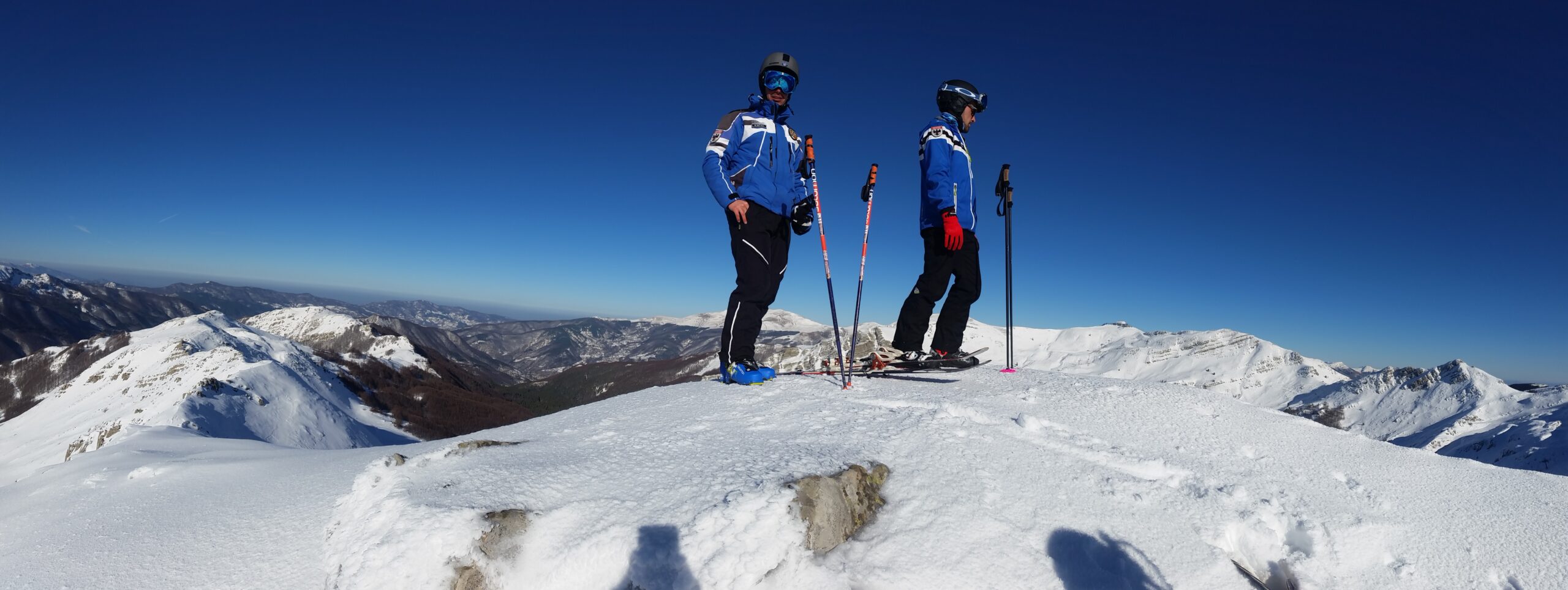Foto di gruppo dei maestri della Scuola di Sci Val di Luce – Abetone, con divise da sci e sfondo panoramico dell’Abetone innevato